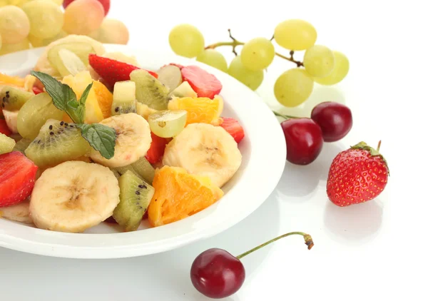 Insalata di frutta fresca su piatto e bacche isolate su bianco — Foto Stock