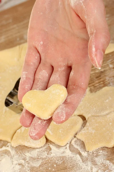 stock image Woman's hand holding the heart made from dough close-up