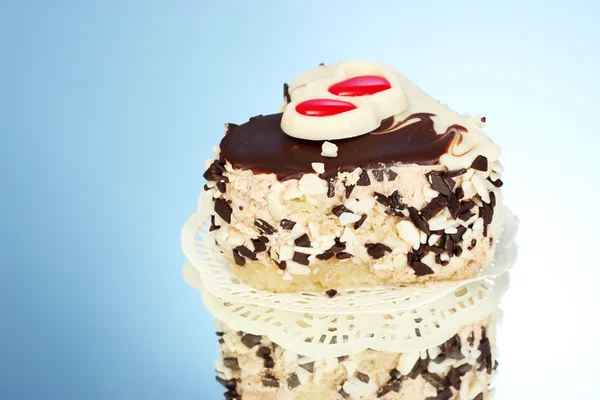 Sladký dort s čokoládou na modrém pozadí — Stock fotografie