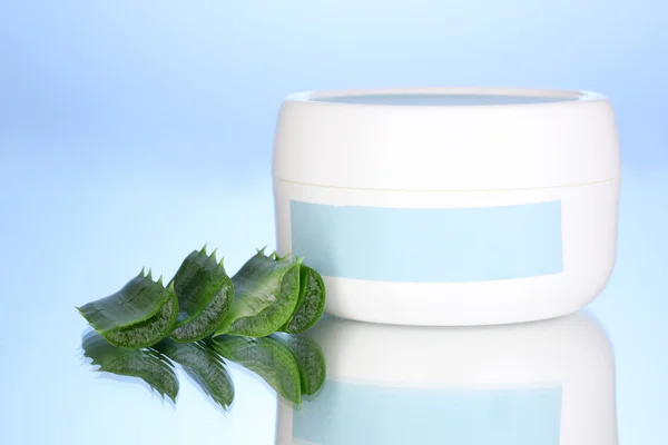 Vasetto di crema con aloe vera su fondo blu — Foto Stock