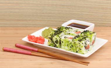 lezzetli rulo ile chopsticks açık renkli ahşap tablo üzerinde beyaz tabakta servis