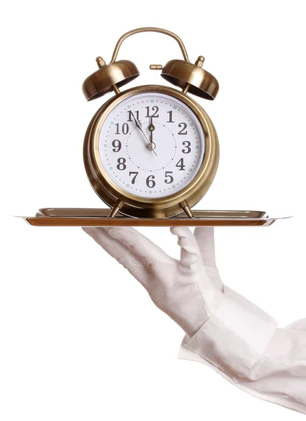 Hand i handske håller silverbricka med väckarklocka isolerad på vit — Stockfoto