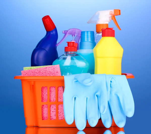Cesta com itens de limpeza em fundo azul — Fotografia de Stock
