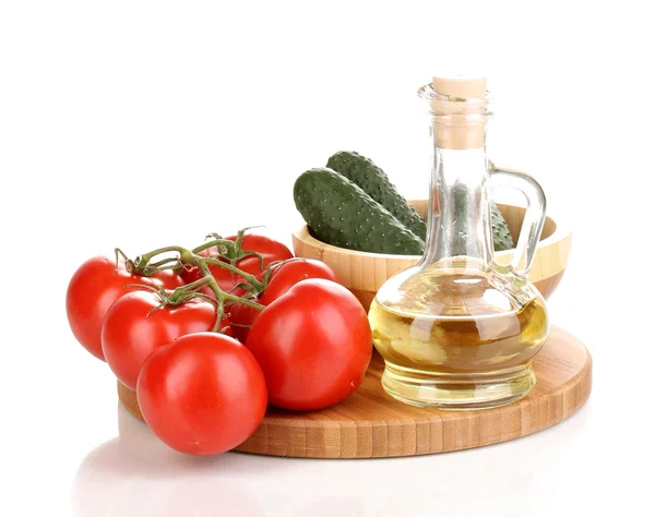 Tomates y pepinos con aceite sobre tabla de madera aislada sobre blanco —  Fotos de Stock