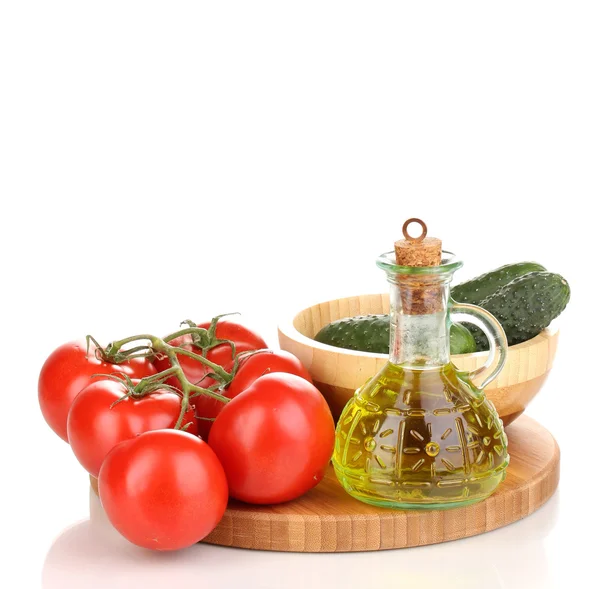 Tomates e pepinos com óleo sobre tábua de madeira isolada em branco — Fotografia de Stock