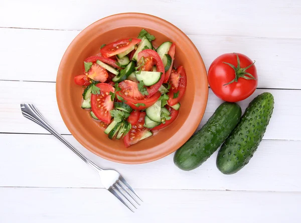 Friss saláta, paradicsom és uborka, fehér fa háttér — Stock Fotó