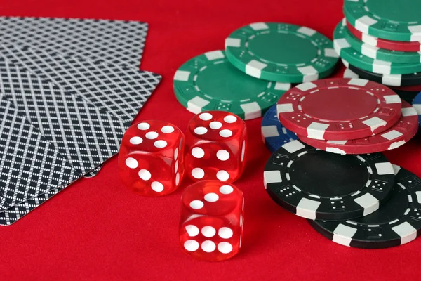Фишки для покера, кости и карты на красном столе — стоковое фото