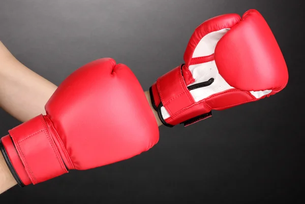 Röd boxning handskar på händerna på grå bakgrund — Stockfoto