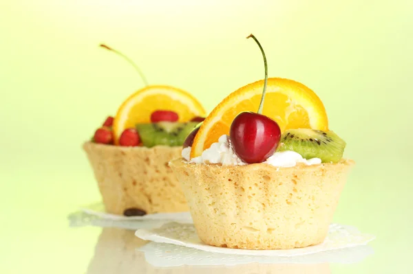 녹색 배경에 과일과 달콤한 케이크 — 스톡 사진