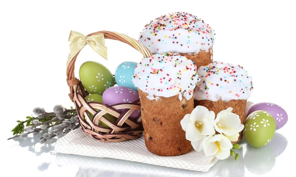 Hermosos pasteles de Pascua, huevos coloridos en cesta y flores aisladas en blanco — Foto de Stock
