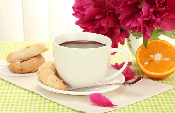 Pohár horká čokoláda, cookies a květiny na stole v kavárně — Stock fotografie