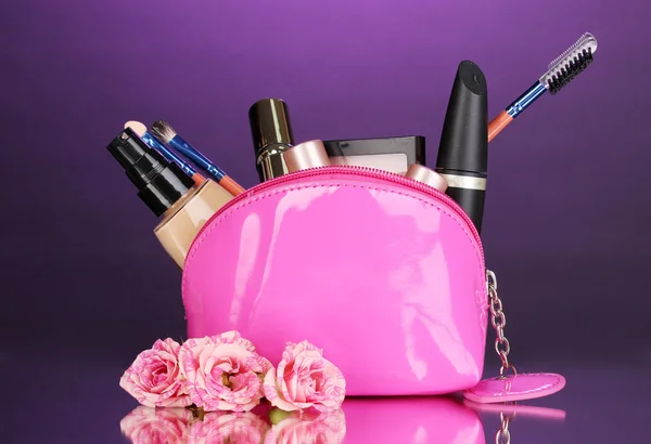 Make-up tas met cosmetica en borstels op violette achtergrond — Stockfoto