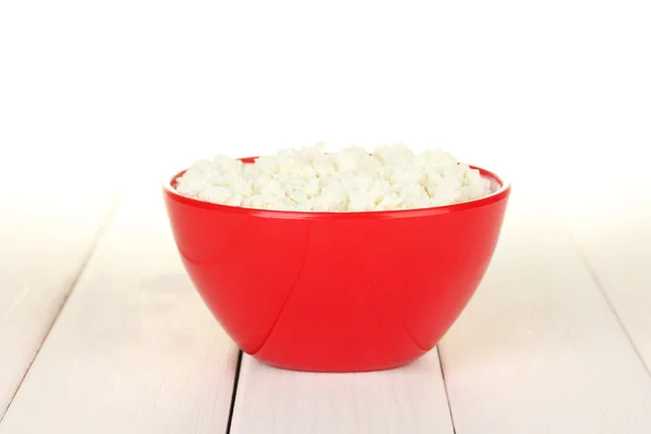 Cottage cheese in red bowl on white wooden table — Stock Photo, Image