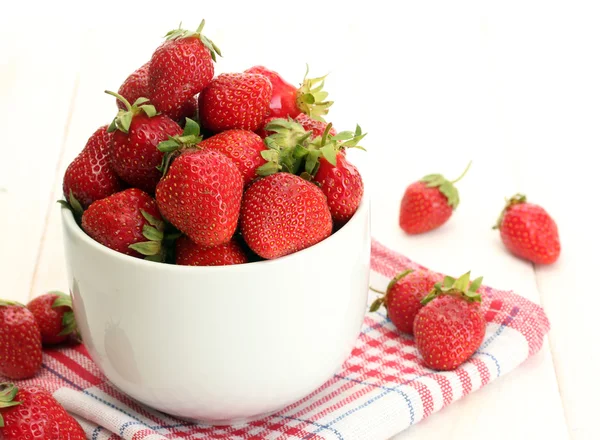 Söt mogna jordgubbar i skål på vita träbord — Stockfoto