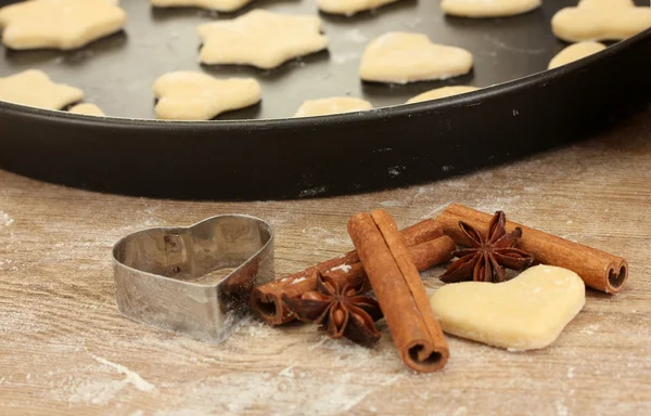 Ungebackene Kekse auf einer Pfanne mit Ausstecher für Kekse, Zimt und Anis in Nahaufnahme — Stockfoto