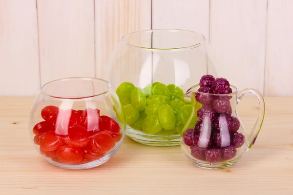 Color candies in glasses on wooden background — Stock Photo, Image