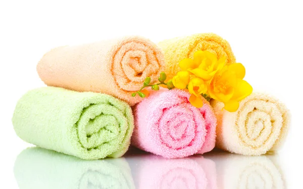 Kleurrijke handdoeken en bloemen geïsoleerd op wit — Stockfoto