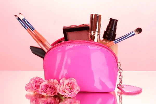 Bolsa de maquillaje con cosméticos y pinceles sobre fondo rosa —  Fotos de Stock