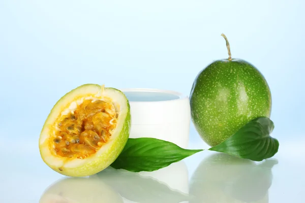 Zelené passion ovoce s kosmetické krém na modrém pozadí detail — Stock fotografie