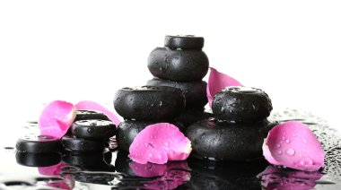 Spa stones with drops and rose petals on white background