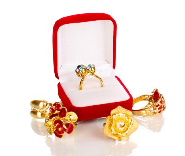 Gold ring with blue, black, lilac and clear crystals in red velvet box and four golden rings isolated on white clipart