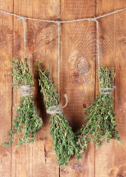 Fresh green thyme hanging on rope on wooden background — Stock Photo, Image