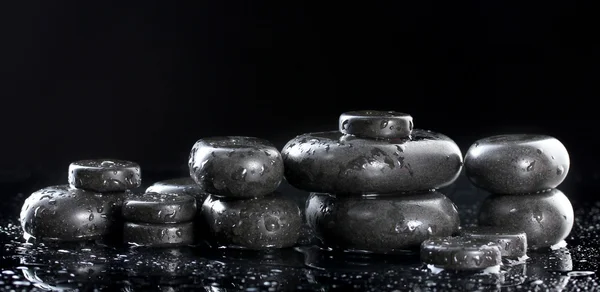 Wellness-Steine mit Tropfen auf schwarzem Hintergrund — Stockfoto