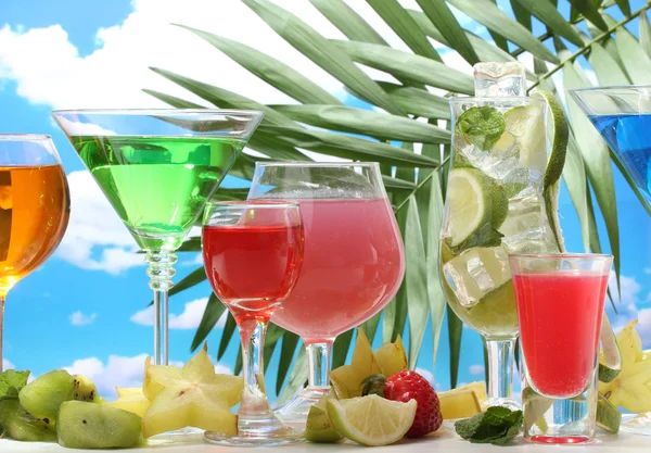 Bicchieri di cocktail sul tavolo su sfondo cielo blu — Foto Stock