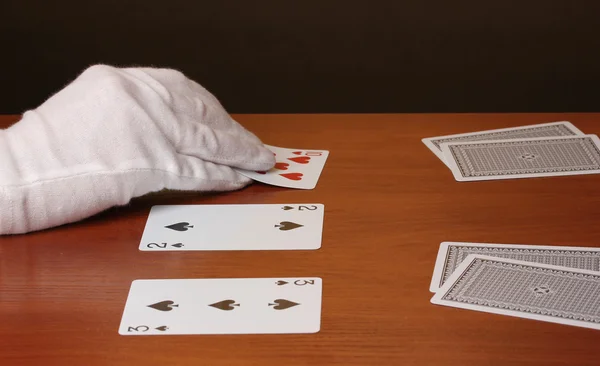 Kortit ja käsi ruskealla taustalla — kuvapankkivalokuva