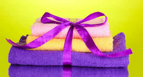 Kleurrijke handdoeken met lint op groene achtergrond — Stockfoto