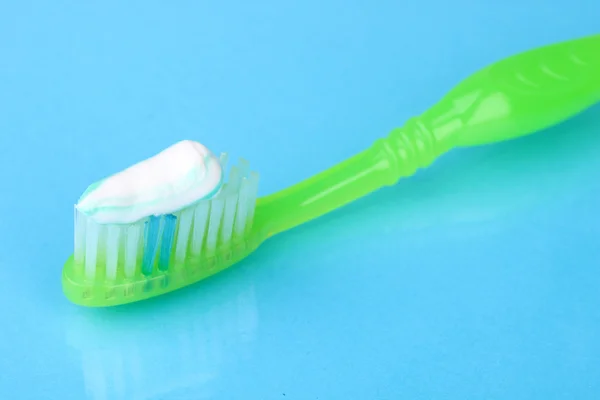 Toothbrush with paste on blue background — Stock Photo, Image