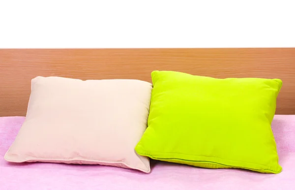Almohadas brillantes en la cama sobre fondo blanco —  Fotos de Stock