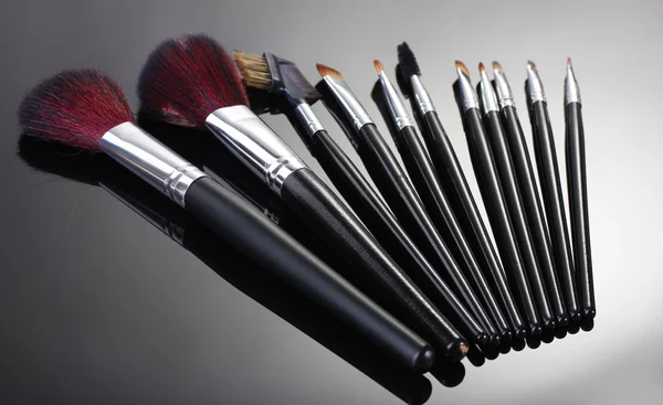 Pincéis de maquiagem em fundo cinza — Fotografia de Stock