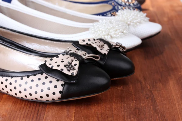 Plusieurs paires de chaussures plates féminines sur fond en bois — Photo