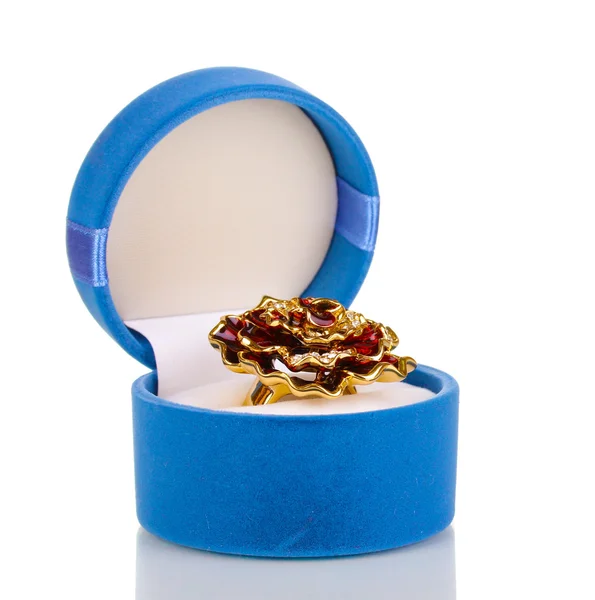 Χρυσό δαχτυλίδι με μεγάλο κόκκινο λουλούδι και σαφή κρύσταλλα σε μπλε βελούδο κουτί που απομονώνονται σε λευκό — Φωτογραφία Αρχείου
