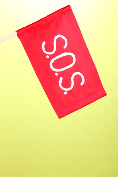 Segnale SOS scritto su stoffa rossa su sfondo verde — Foto Stock