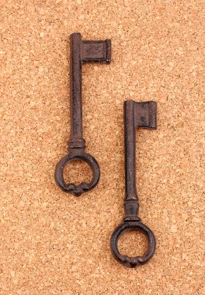 Two antique keys on cork background — Stock Photo, Image