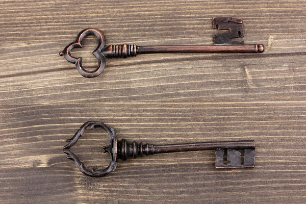 Duas chaves antigas no fundo de madeira — Fotografia de Stock