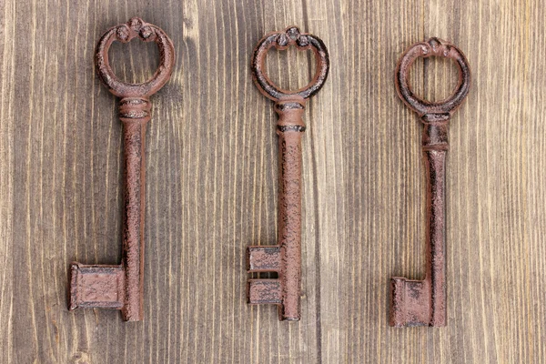 Trois clés antiques sur fond en bois — Photo