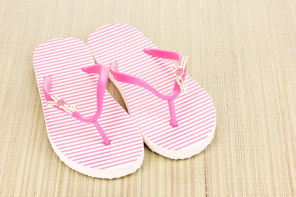 Pink beach slippers on mat — Stock Photo, Image