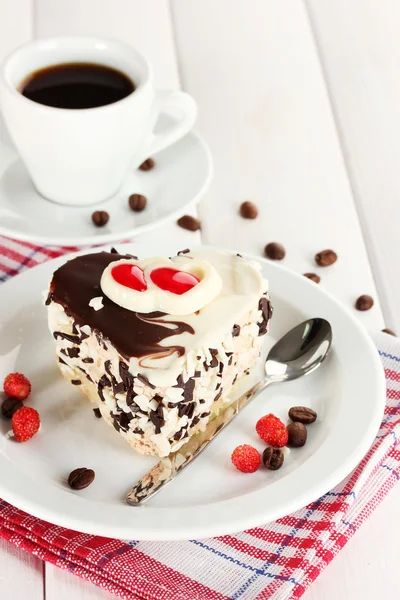 Słodkie ciasto z czekolady na płytkę i filiżankę kawy na drewnianym stole — Zdjęcie stockowe