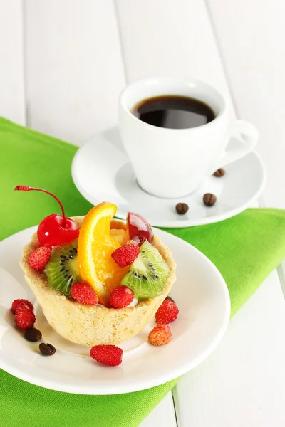Pastel dulce con frutas en el plato y taza de café en la mesa de madera —  Fotos de Stock