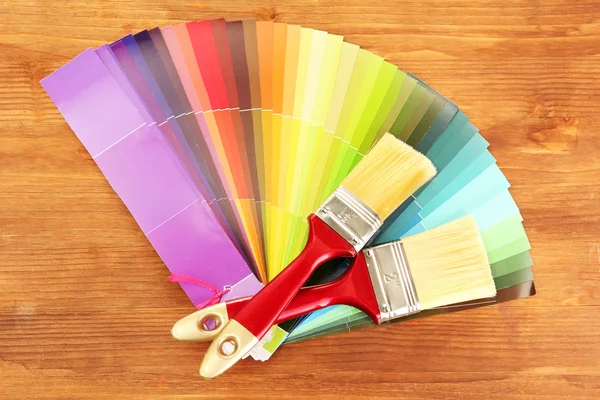 Boya fırçaları ve renk ahşap zemin üzerinde parlak paleti — Stok fotoğraf