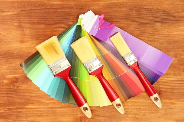 Pinceles y paleta de colores sobre fondo de madera — Foto de Stock