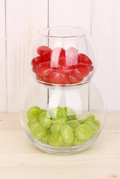Цветные конфеты в стаканах на деревянном фоне — стоковое фото