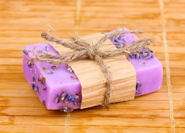 Лавандовое мыло ручной работы на деревянном коврике — стоковое фото