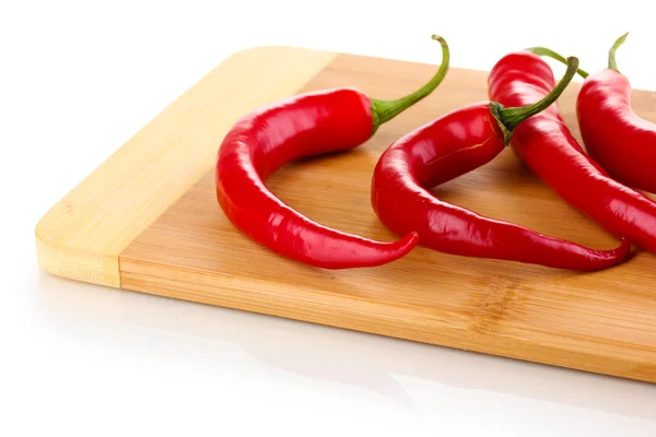 Red hot chili papričky na dřevěné prkno izolovaných na bílém — Stock fotografie