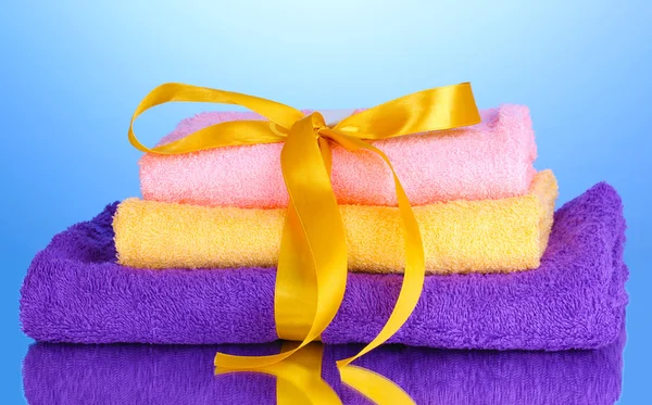 Asciugamani colorati con nastro su sfondo blu — Foto Stock