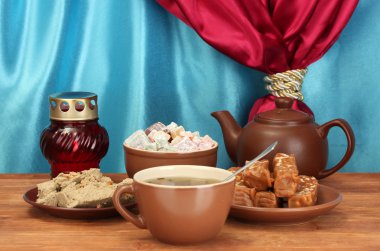 çaydanlık bardak ve tabaklar oryantal tatlılar - şerbet, helva ve Türk lokumu perde yakın çekim bir arka plan üzerinde ahşap masa üzerinde