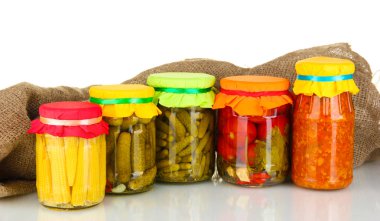 Jars with canned vegetables on canvas background clipart